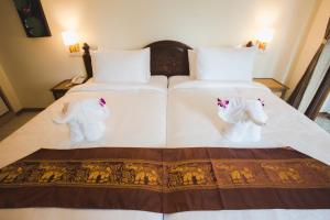 zwei weiße Betten mit Stofftieren darauf in der Unterkunft Chada Mantra Hotel in Chiang Mai