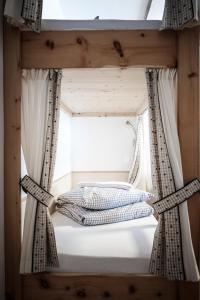 Bett in einem Zimmer mit Fenster in der Unterkunft Gasthof Fallmühle in Pfronten