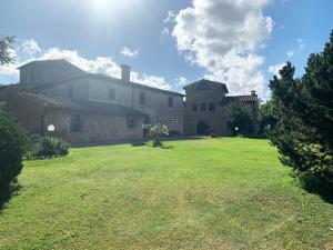 een groot huis met een grasveld ervoor bij S.M. L'ARCO in Monteriggioni