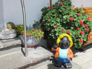 una estatua de un oso parado frente a las flores en Haus Eder Burgi en Nikolsdorf