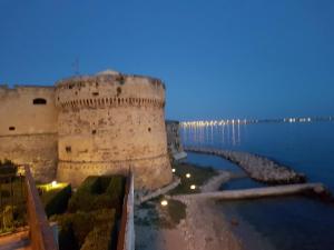 a castle next to a body of water at Philos - Appartements & Rooms in Taranto