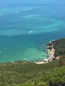 una vista aerea di una spiaggia con barche in acqua di Casa do Farol da Arrábida a Portinho da Arrábida