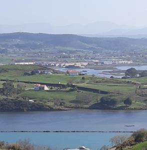 a view of a body of water with houses and fields at APARTAMENTO Luis in Suances