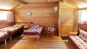 een kamer met 2 bedden en een stoel in een cabine bij Urpolan Kartano Ky in Humppila