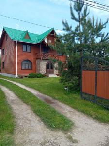 a house with a gate on a dirt road at Shovkova Kosytsia in Mykulychyn