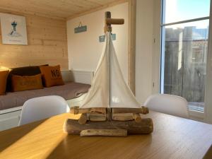 ein hölzernes Segelboot auf einem Tisch in einem Zimmer in der Unterkunft Appartements Les Homards du Fier #3 in La Guérinière