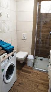 łazienka z pralką i toaletą w obiekcie Słoneczne Tarasy w Dziwnówku