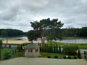 una piccola casa sull'erba vicino a un lago di Apartament nad zalewem przy plaży a Jedlnia-Letnisko