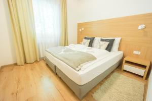 Un pat sau paturi într-o cameră la Praga Apartments & Restaurant Zell am See-Kaprun