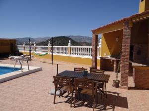 a patio with a table and chairs next to a pool at B&B Casa Sarandy - Casita Mayo in Almogía