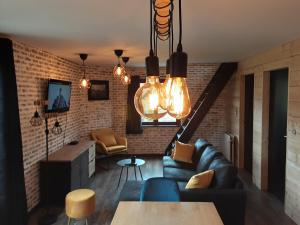 a living room with a couch and a brick wall at LE CHALET in Spa