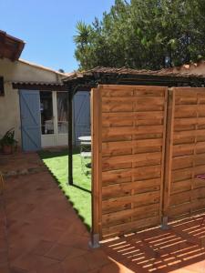 une clôture en bois dans une cour avec de l'herbe dans l'établissement Studio indépendant près cap canaille avec terrasse, à La Ciotat