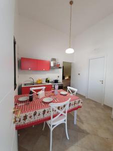 eine Küche mit einem Tisch und einer roten Tischdecke darauf in der Unterkunft Lu Murieddhru in Novoli