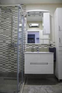 a bathroom with a sink and a shower at Apartman Nina in Sremska Mitrovica