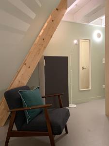 un soggiorno con sedia e scala di Ambiance bois - 2 appartements a Vannes