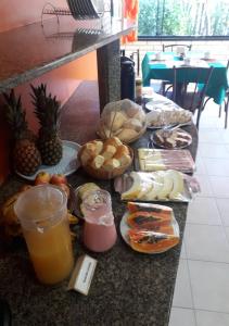 um balcão com um monte de comida e bebidas em Pousada do sol Meaipe em Guarapari