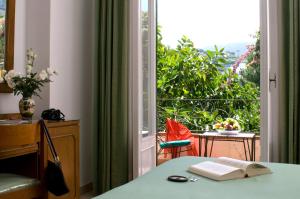 a room with a table with a book and a window at Hotel Villa Angelica in Ischia