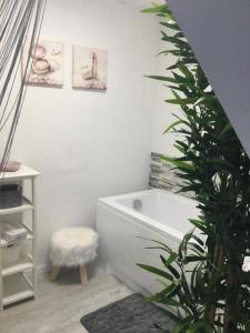 a bathroom with a white tub and a plant at Apartmenthaus Alte Börse in Carolinensiel