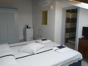 un letto bianco con due asciugamani sopra di Residenza Cuntin a Carloforte