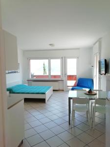 Sala de estar con 2 camas y mesa en LAKE & CASTLE VIEW apartment, en Riva del Garda