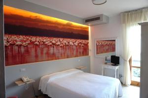 a bedroom with a painting of flamingos on the wall at Hotel Atlantico in Castiglioncello