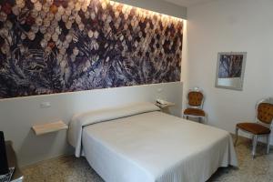 a bedroom with a bed and a painting on the wall at Hotel Atlantico in Castiglioncello