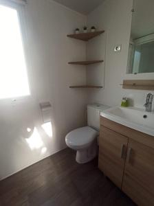 a bathroom with a white toilet and a sink at VIAS Plage La Carabasse - Mobile home 6 places in Vias