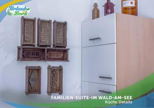 a refrigerator with wooden frames and bottles on a wall at Familien-Suite-im-Wald-am-See in Bork