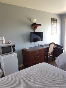 um quarto com uma secretária, um computador e uma cama em Motel des Mariniers em Kamouraska