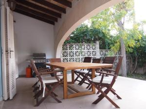 a wooden table and chairs on a patio at Chalet Sa Marina in Port d'Alcudia