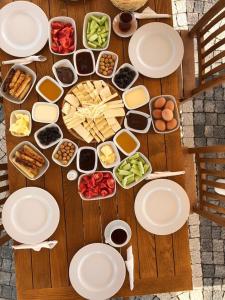 a wooden table with plates and food on it at Ersin Konak in Bozcaada