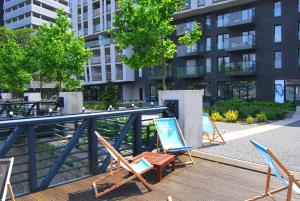 a group of chairs sitting on a deck in front of a building at TWO TOWERS Old Town Apartments-City center-by the river-observation terrance on the roof-free parking in Wrocław