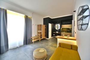 a living room with a yellow couch and a table at Hydra Icons in Hydra