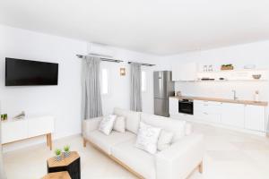 a white living room with a white couch and a kitchen at Salty Villas, Chrissipi in Antiparos