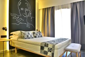 Schlafzimmer mit einem Bett mit einer schwarz-weißen Wand in der Unterkunft Hydra Icons in Hydra