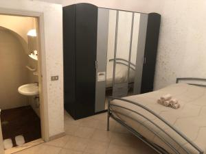 a bedroom with a bed and a bathroom with a sink at Il rifugio di Vaaz in Sammichele di Bari