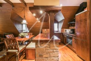 cocina con paredes de madera, mesa de madera y sillas en Sarrahèra by SeaMount Rentals, en Baqueira Beret