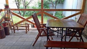 einen Holztisch und Stühle auf einer Terrasse in der Unterkunft Villa Svalyavа in Swaljawa