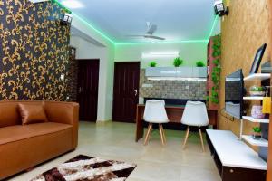 un soggiorno con divano e 2 sedie bianche di Green Royale Living Spaces - Luxury Serviced Apartments a Trivandrum