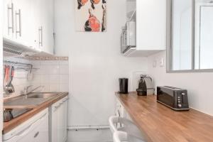 een kleine keuken met een wastafel en een magnetron bij Studio Vue Mer in Saint-Martin-de-Ré