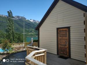 a house with a wooden door on a deck at Summer haus in Syreflot