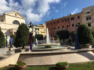 een fontein in het midden van een stad met gebouwen bij Casa Stella Marina in Anzio