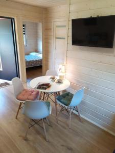 a room with a table and chairs and a tv at Czerwone Domki Wartowo in Kołczewo