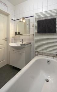 a white bathroom with a tub and a sink at Apartment Ferienwohnung Blumenstadt in Erfurt +20 photos