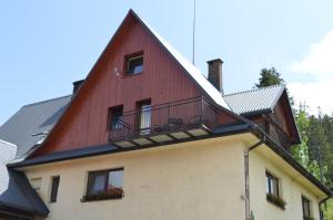 ein rotes Gebäude mit Balkon darüber in der Unterkunft Agroturystyka Skałka in Wisła