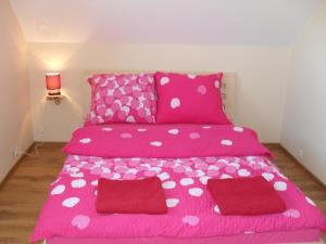 a pink bed with pink and white polka dots at Gościniec Mazurek in Giżycko