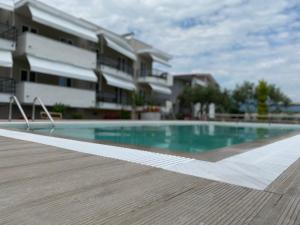 uma piscina em frente a um edifício em Littore Maris em Nea Vrasna