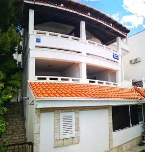 una casa blanca con techo naranja en Apartments Fani, en Brela