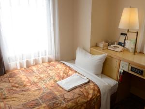 Postel nebo postele na pokoji v ubytování Nagoya Sakae Green Hotel