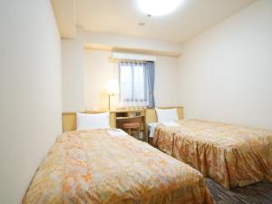 Postel nebo postele na pokoji v ubytování Nagoya Sakae Green Hotel